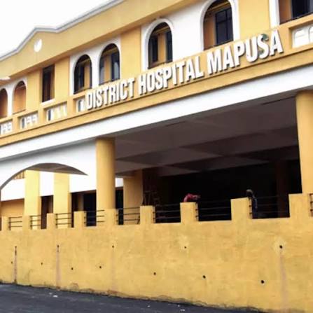 The image shows the exterior facade of the North Goa District Hospital (Asilo Hospital) located in Mapusa, Goa.